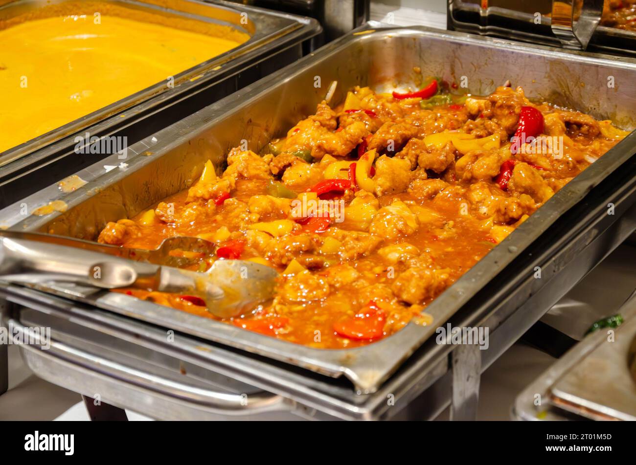 Hot food at a self service buffet kept warm in chafing dishes at a party in a hotel Stock Photo