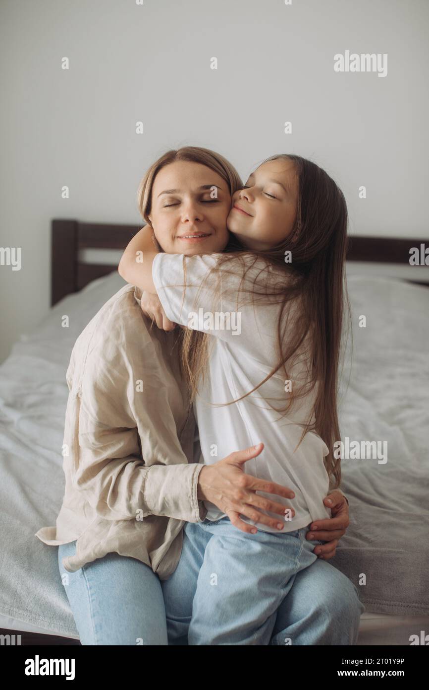 Mother's Day. A little daughter lovingly hugs her mother. Stock Photo