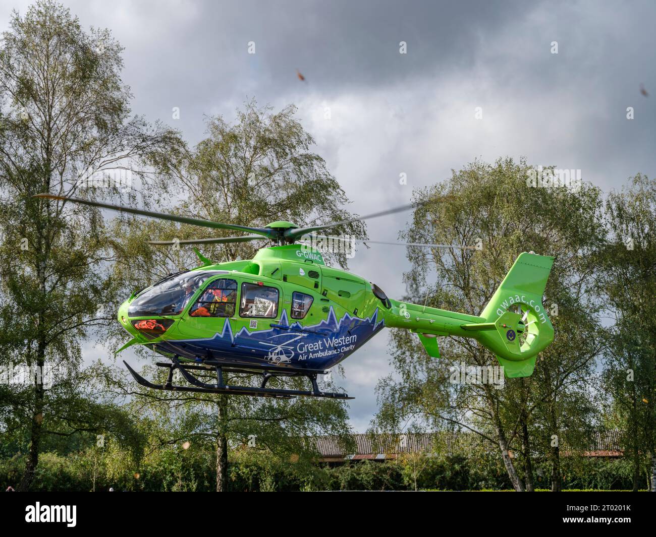 The Great Western Air Ambulance lifts off from outside Gloucester Royal Hospital. The bright lime green and blue helicopter, call sign Helimed 65, is Stock Photo