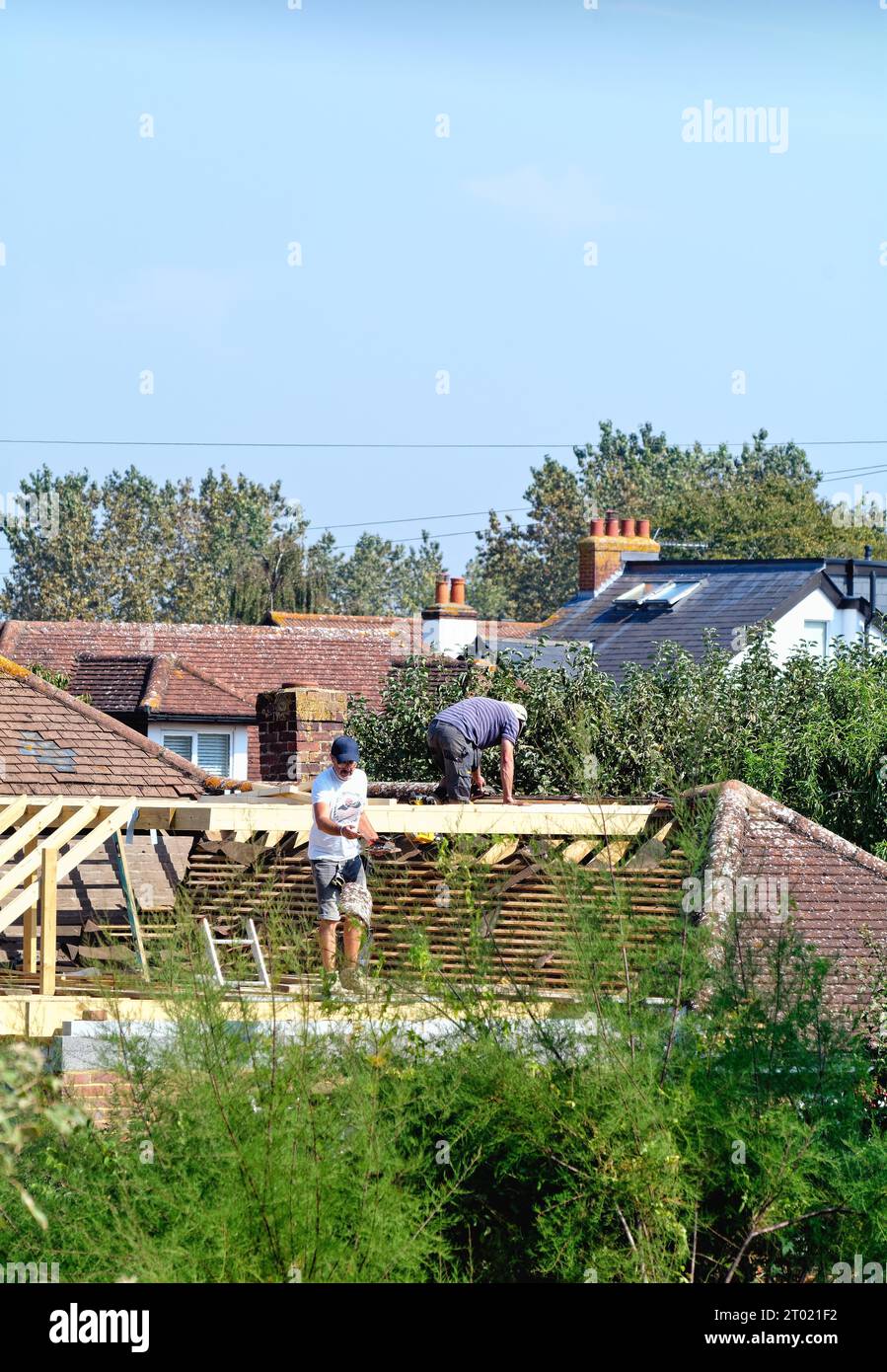 Builders working on a roof  extension  to a suburban bungalow in Shepperton Surrey England UK Stock Photo