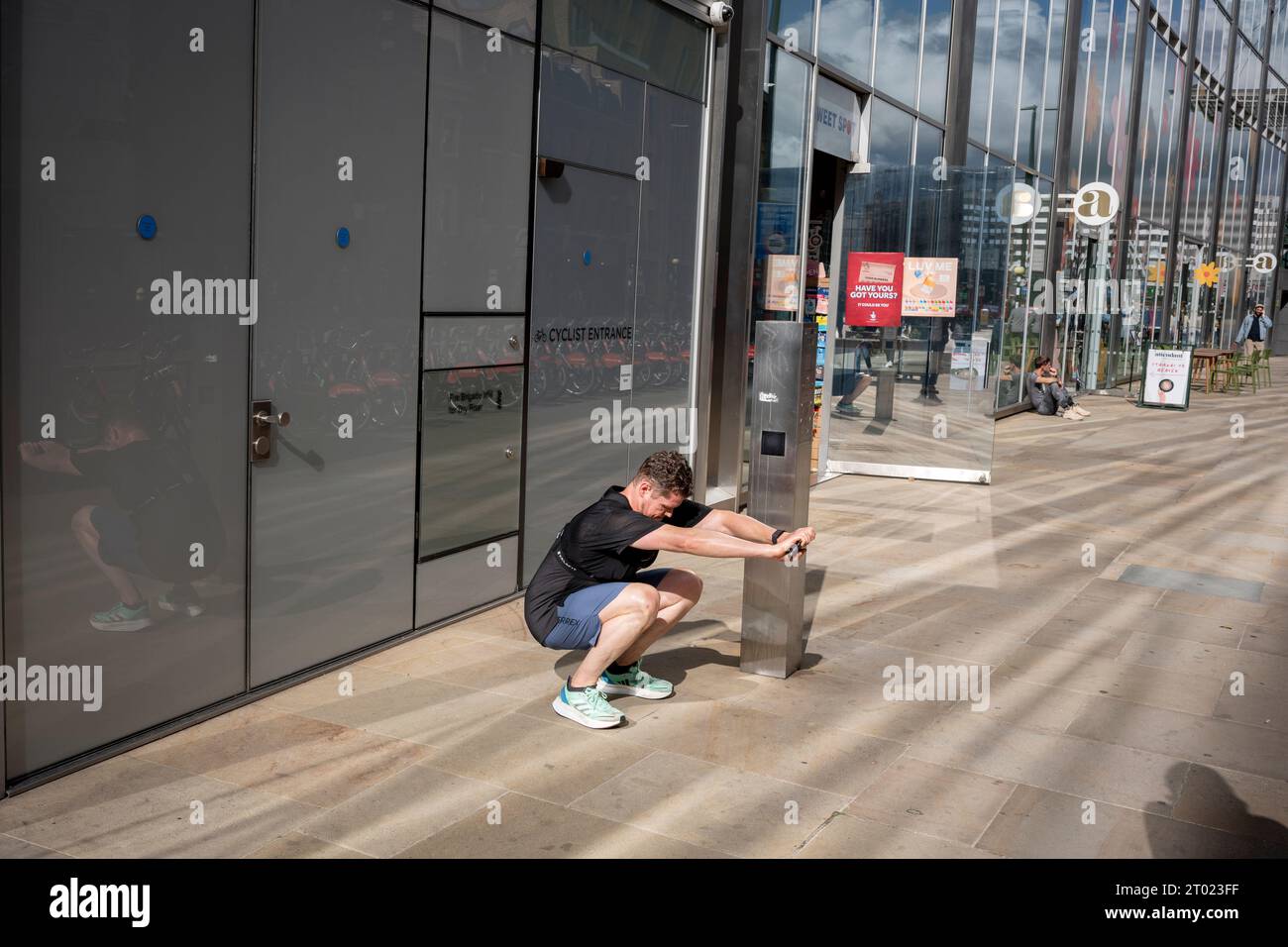 A runner warms-down with stretches after excersing in the City of London, the capital's financial district, on 3rd October 2023, in London, England. Stock Photo