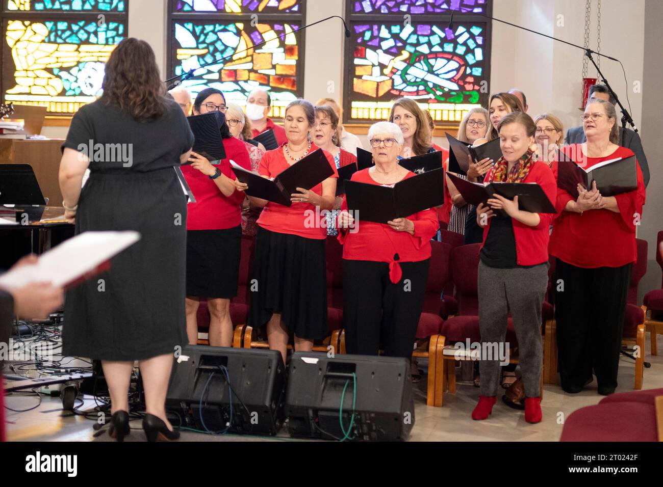 Austin Texas USA, October 1 2023: Choir director leads church choir members in song during ordination ceremony for Cecilia Suknaic Saulnier at Triumphant Love Lutheran Church. ©Bob Daemmrich Stock Photo