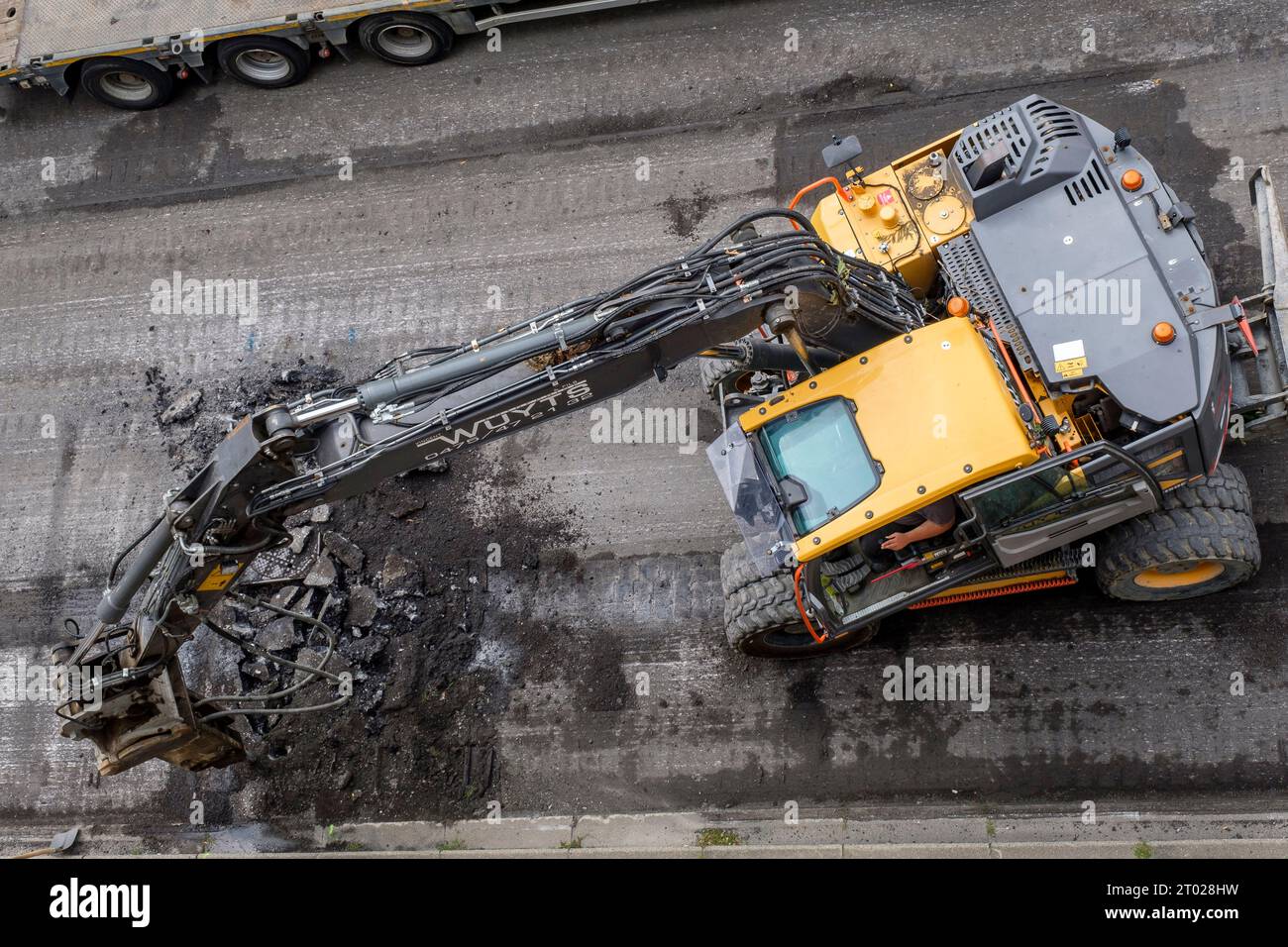 Scraping the macadam and asphalt out of a street in Brussels | Les machines grattent l'ancien revetement en asphalte ou macadam de la rue ainsi que le Stock Photo