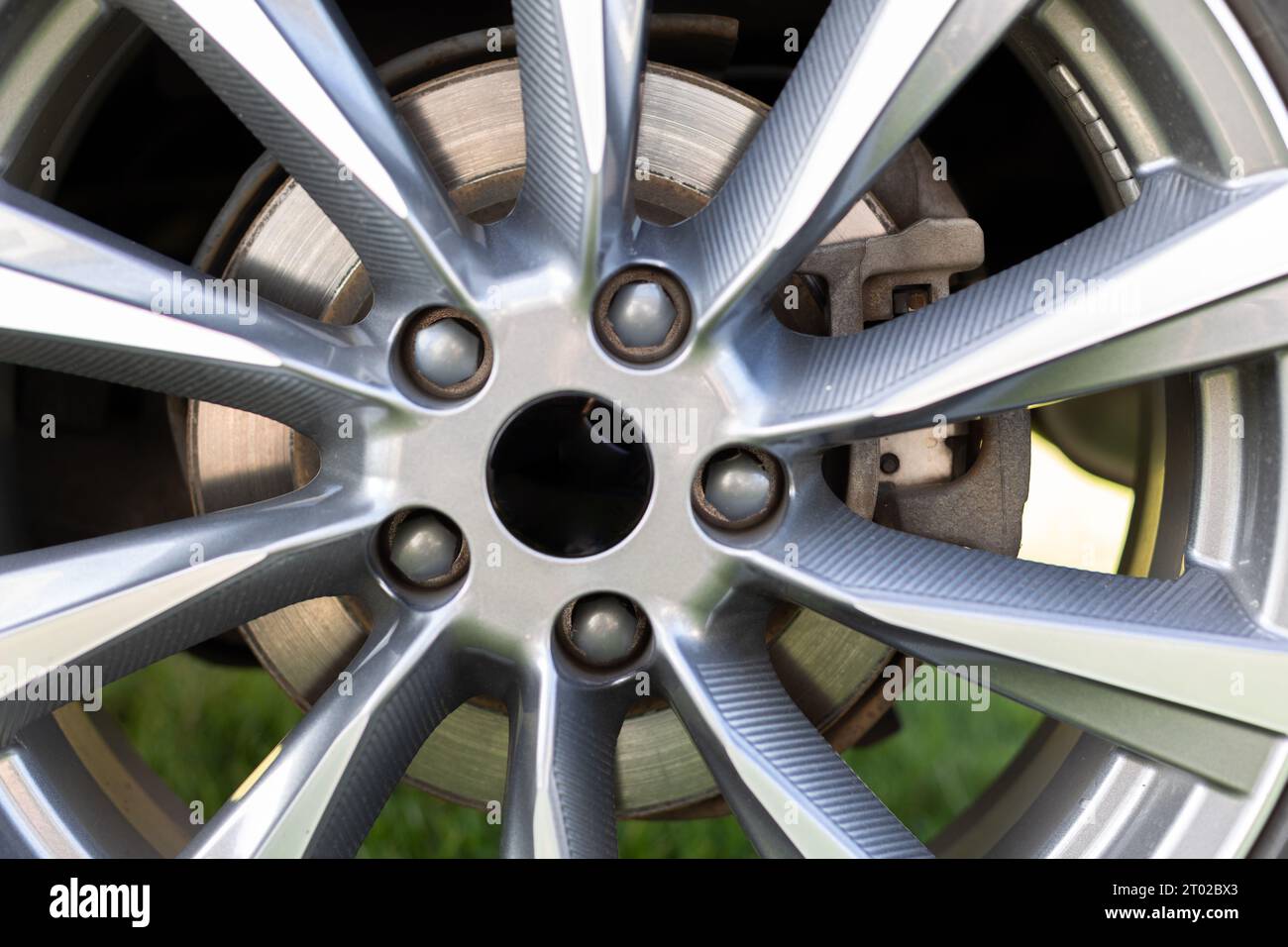 Grey steel brake caliper behind alu rims, on an road car Stock Photo