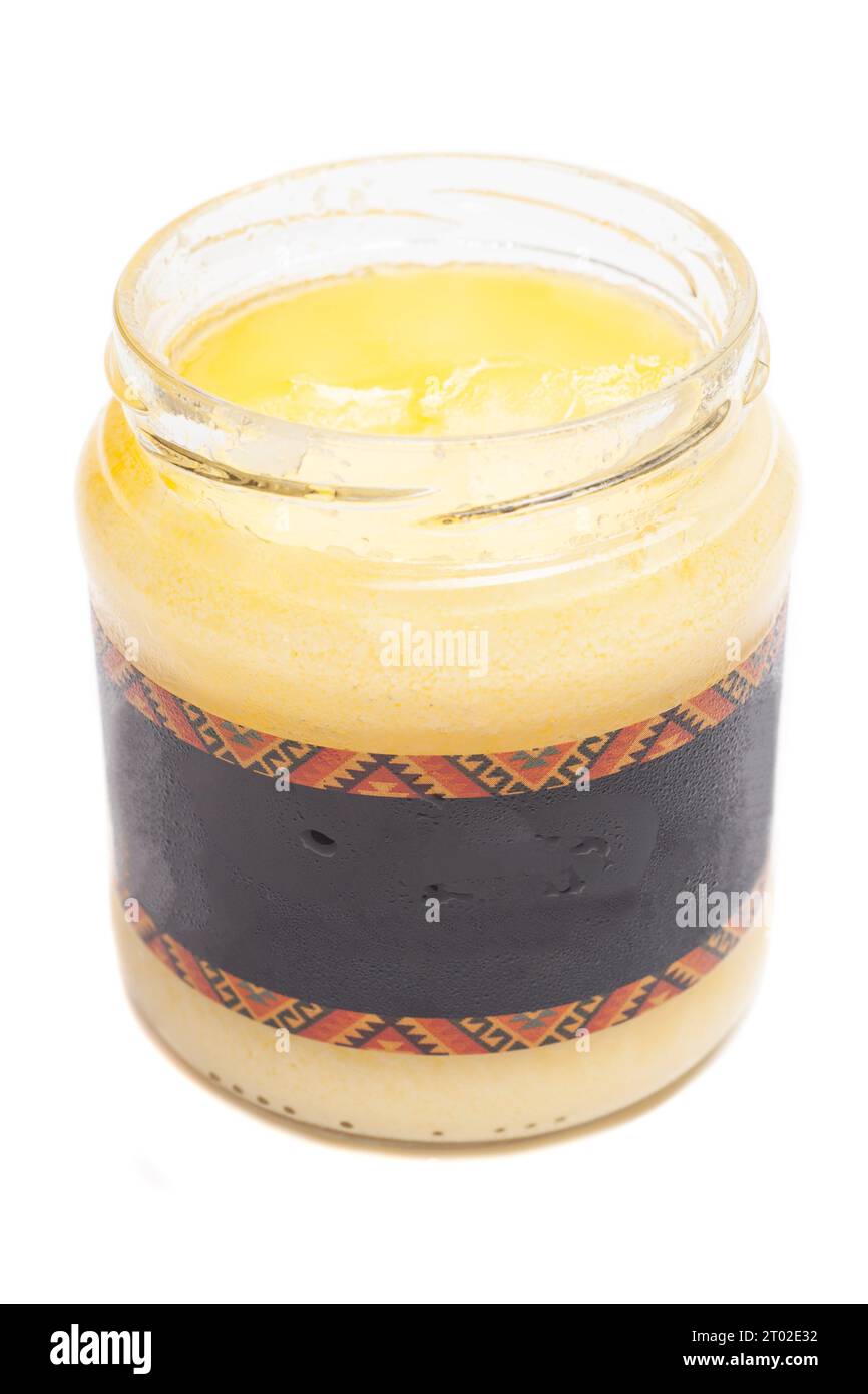 Ghee clarified butter in glass jar isolated on white background Stock