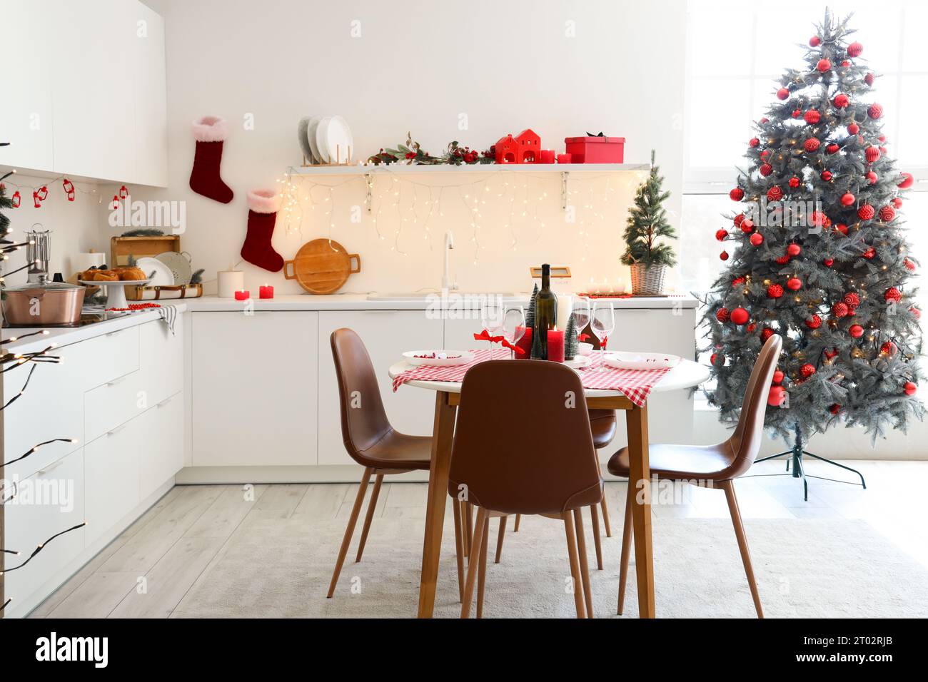 Interior of modern kitchen with festive table setting, Christmas tree ...