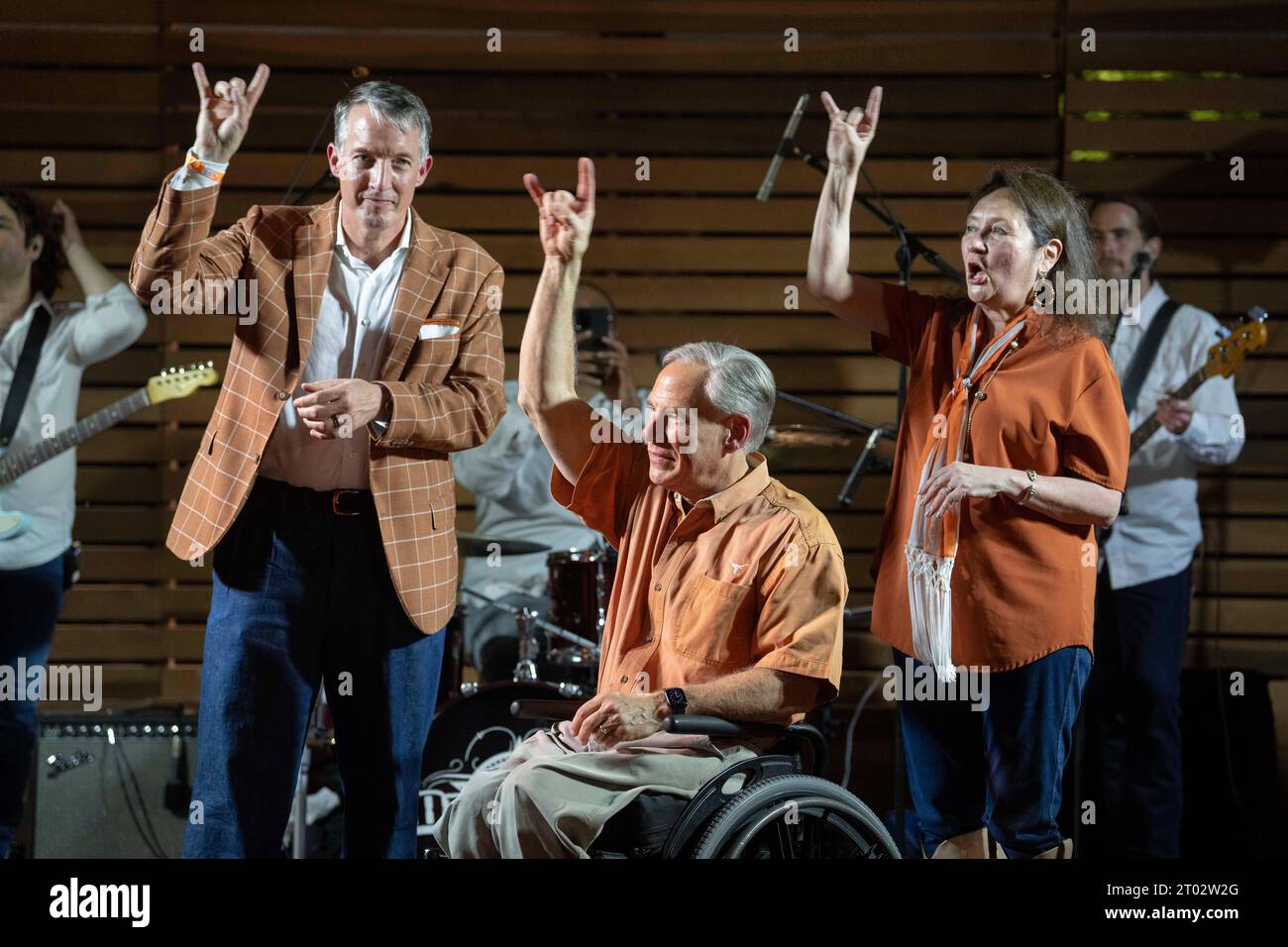 University of Texas President JAY HARTZELL (left) flashes the hook-em-horns with Texas Governor GREG ABBOTT and first lady DECILIA ABBOTT at a 'tailgate party' hosted by the Abbotts the evening before a football game between undefeated Texas (4-0) and Kansas (4-0) in Austin on September 29, 2023.  Several hundred Longhorn fans roamed the grounds and toured the governor's mansion. ©Bob Daemmrich Stock Photo