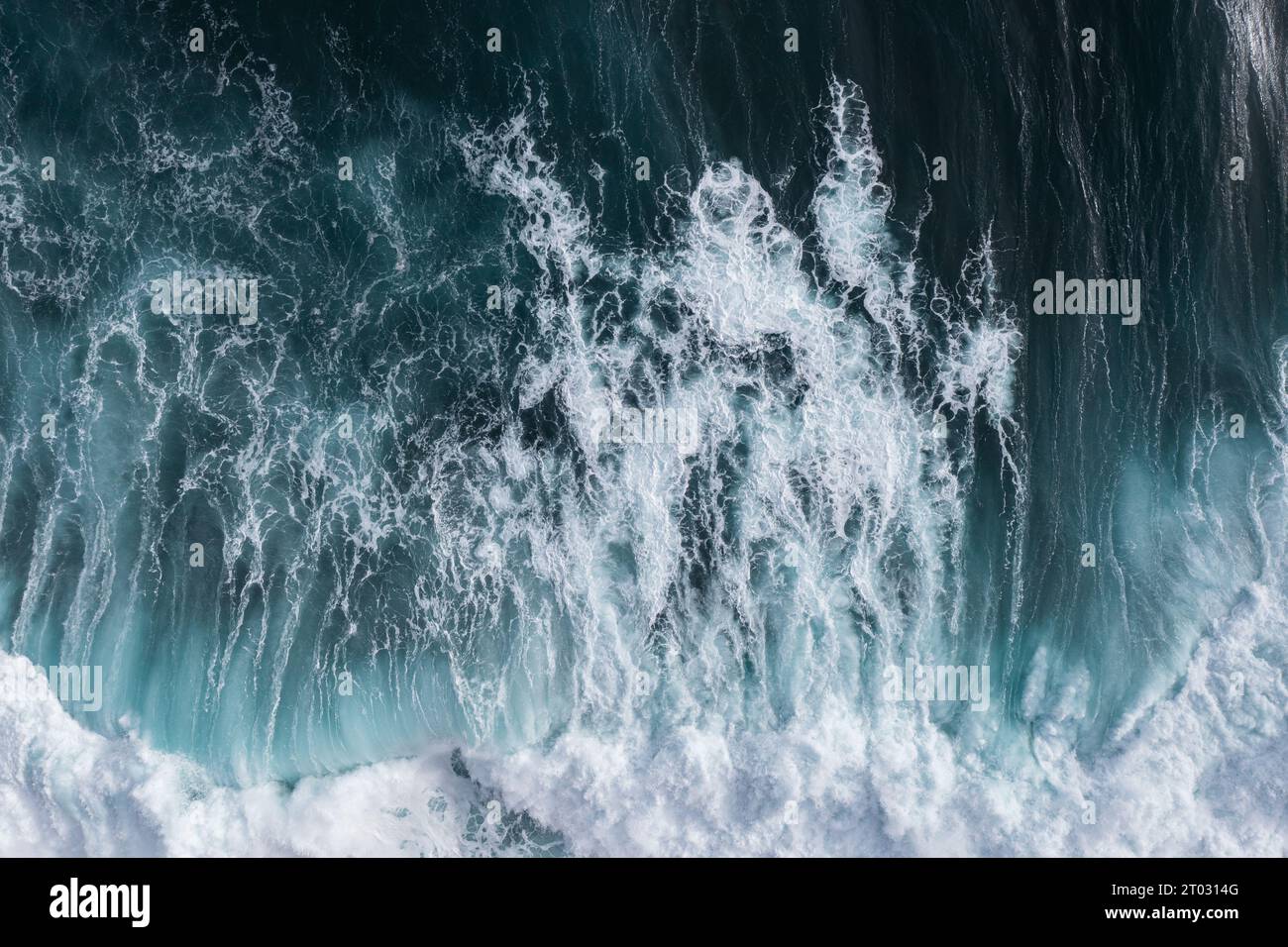Perfect waves for surfing. The waves splash into the turquoise water off the coast. Stock Photo