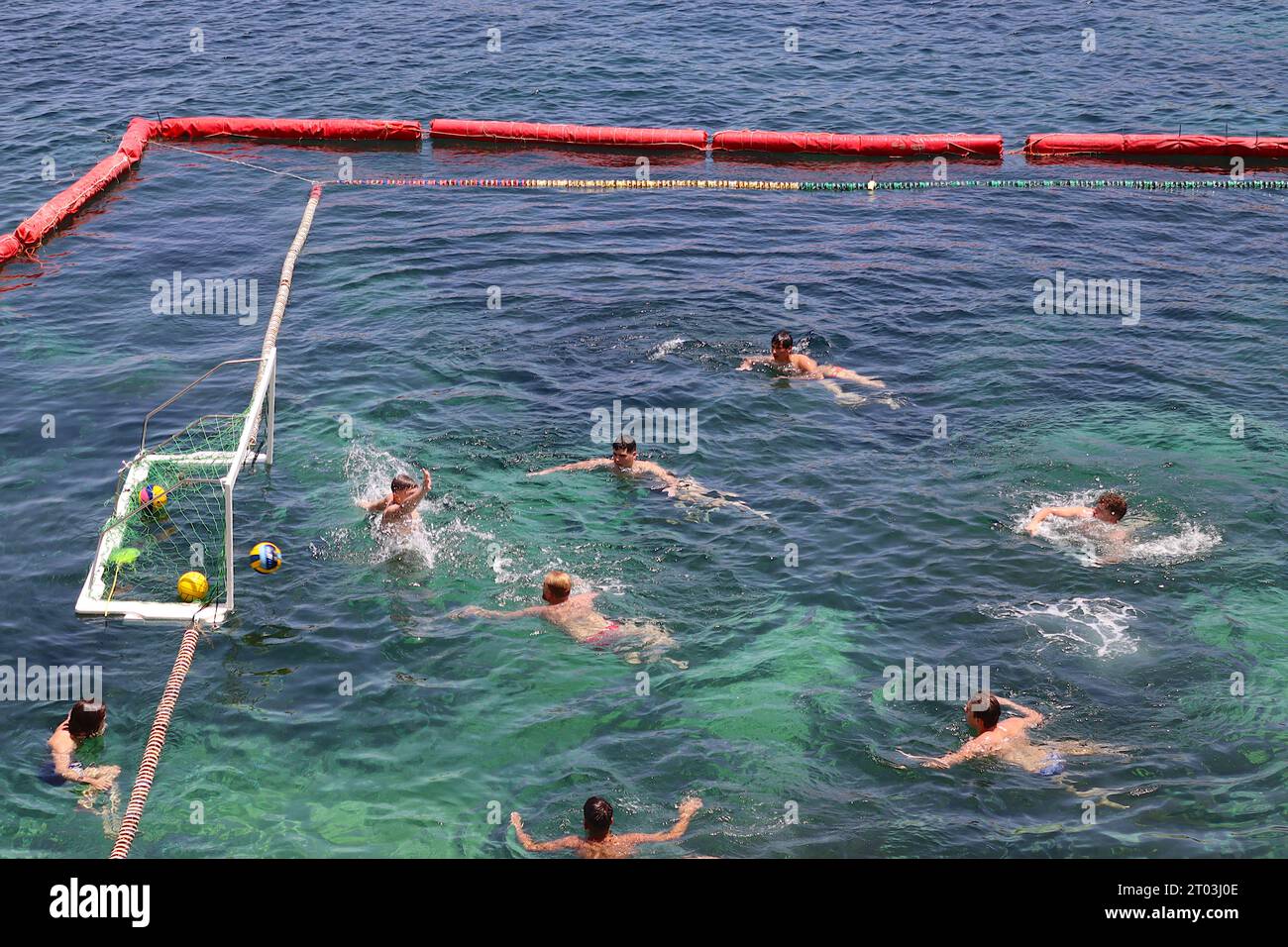 A water polo player scores a goal during a training session in a sectioned off part of the Mediterranean bay at Marsalforn, Gozo, Malta, June 2022. Stock Photo