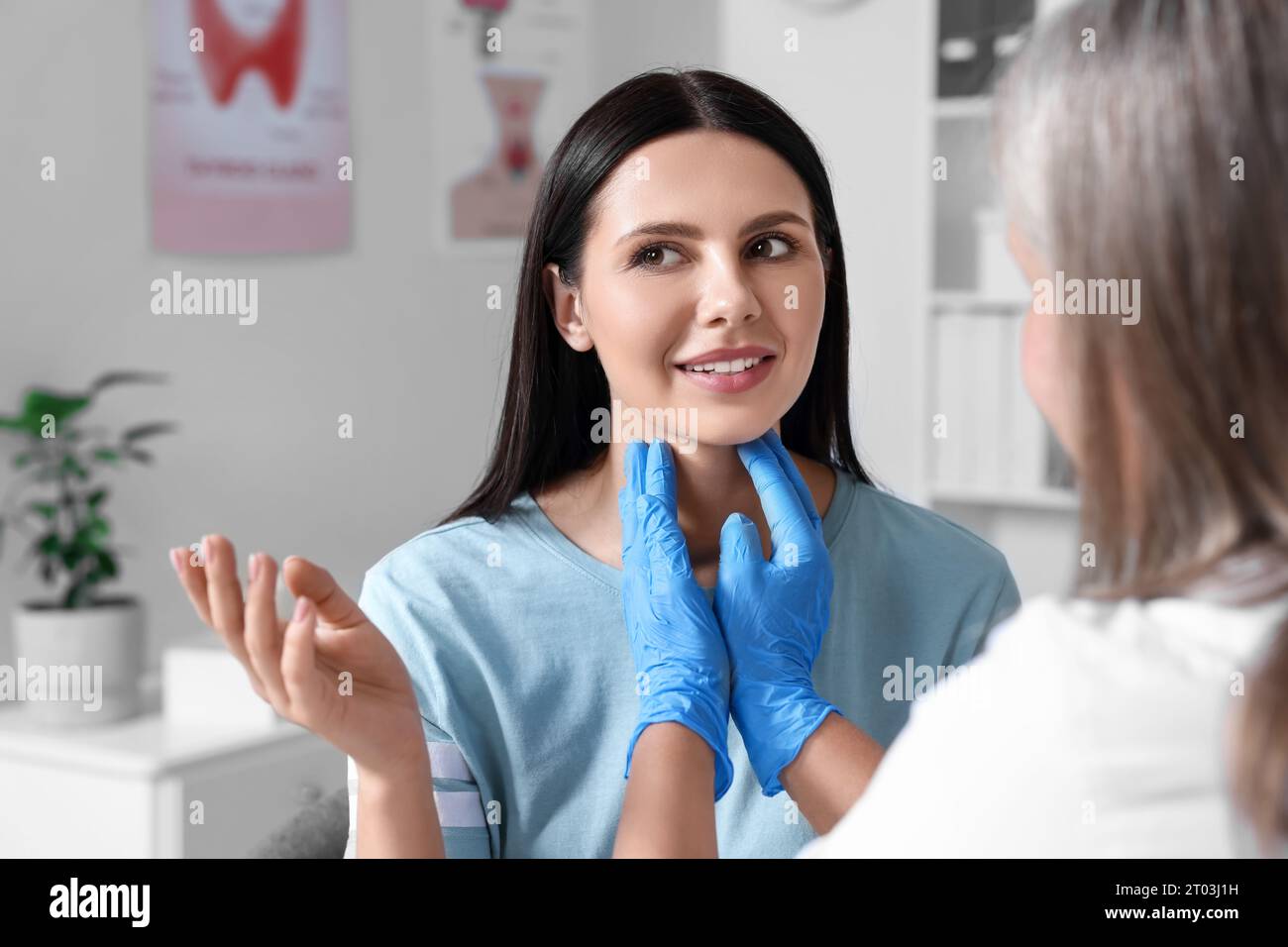 Endocrinologist examining thyroid gland of patient at hospital Stock