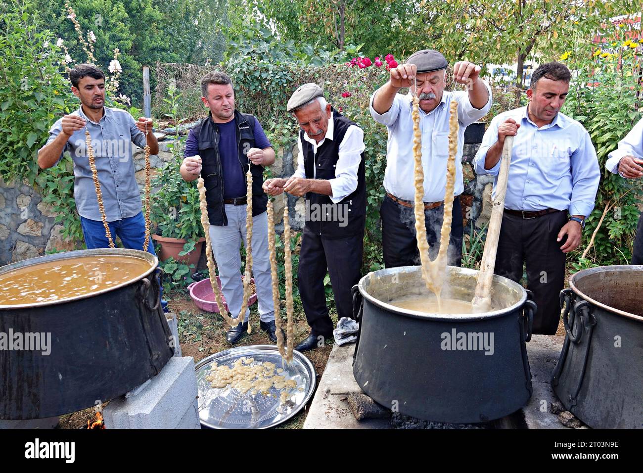 Diyarbakir, Turkey. 01st Oct, 2023. Villagers dip walnuts lined up on a rope into grape juice