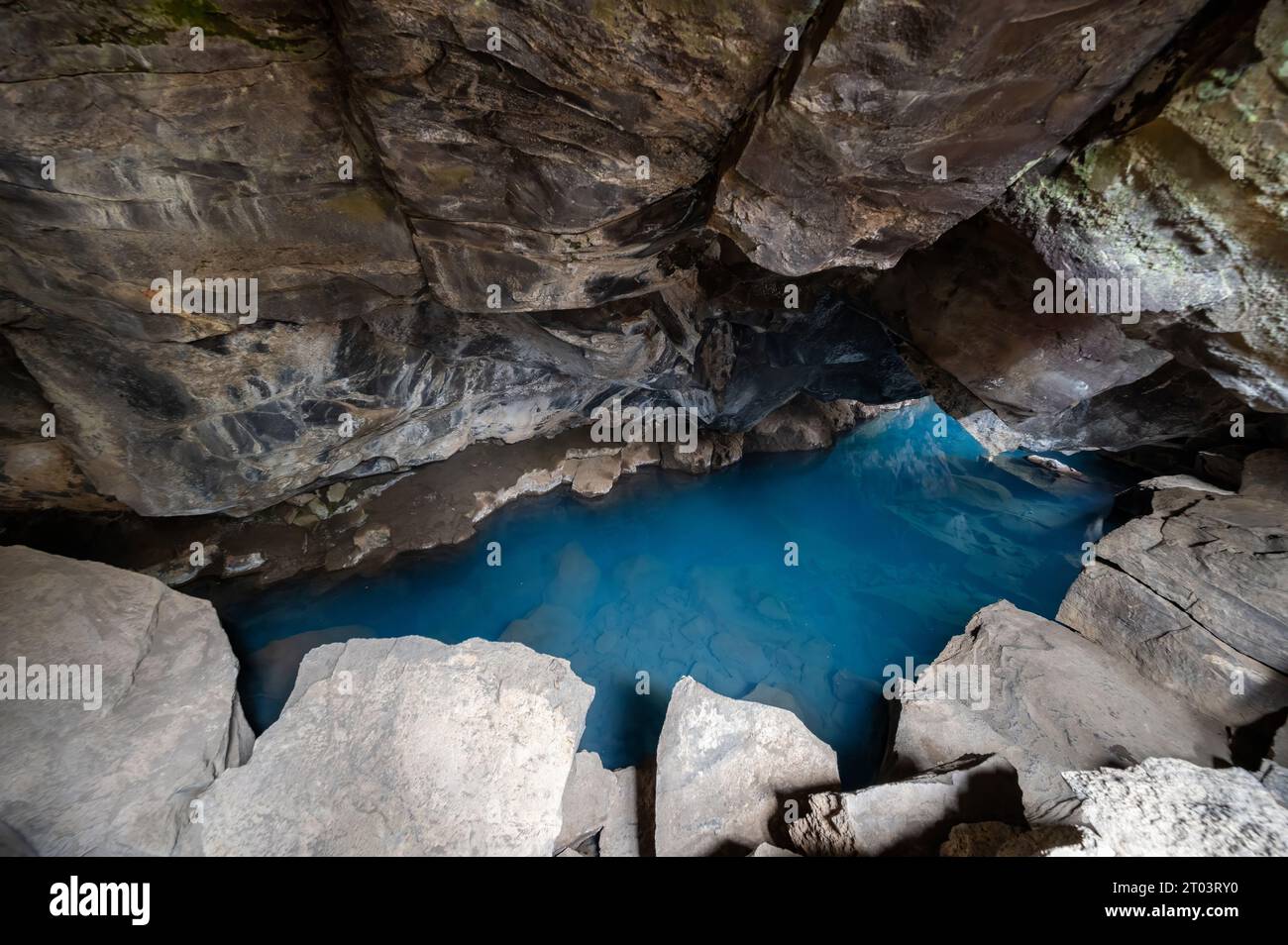 Blue pool in Grjotagja lava cave and fissure in Myvatn, Iceland under autumn afternoon cloudscape. Stock Photo