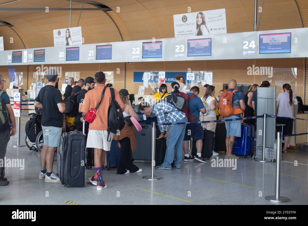 Poznan, Poland - August 25, 2023: People queuing to the check-in counters at Poznan Lawica Airport. Stock Photo