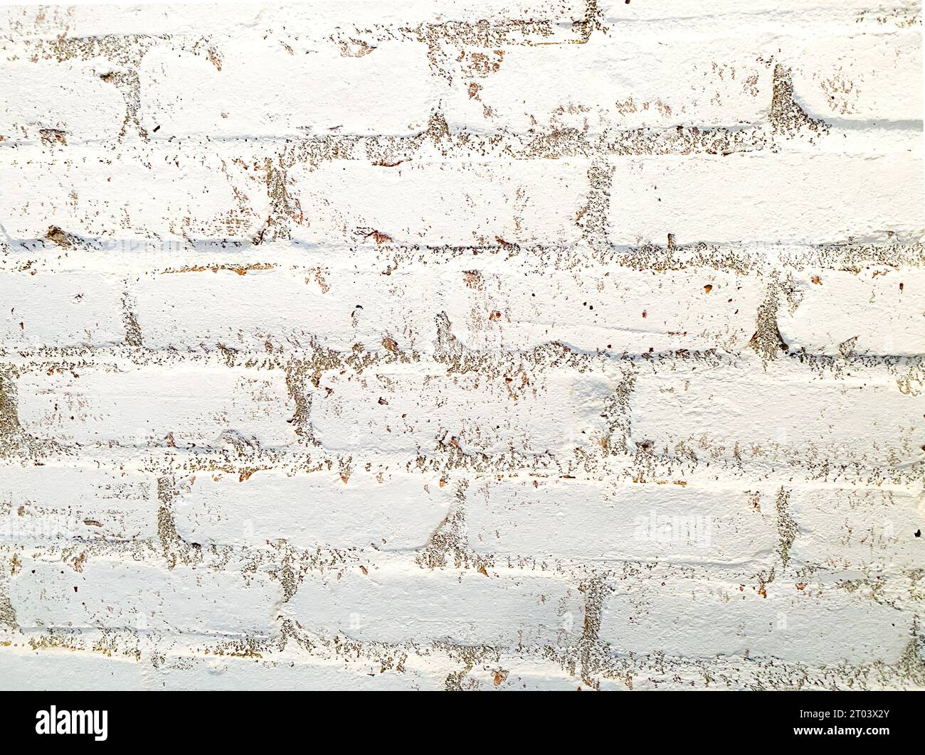 White brick wall in close up. Interior brick wall, painted white with a bit of dirt and imperfect, rough texture, worn by time. Suitable as background. Stock Photo