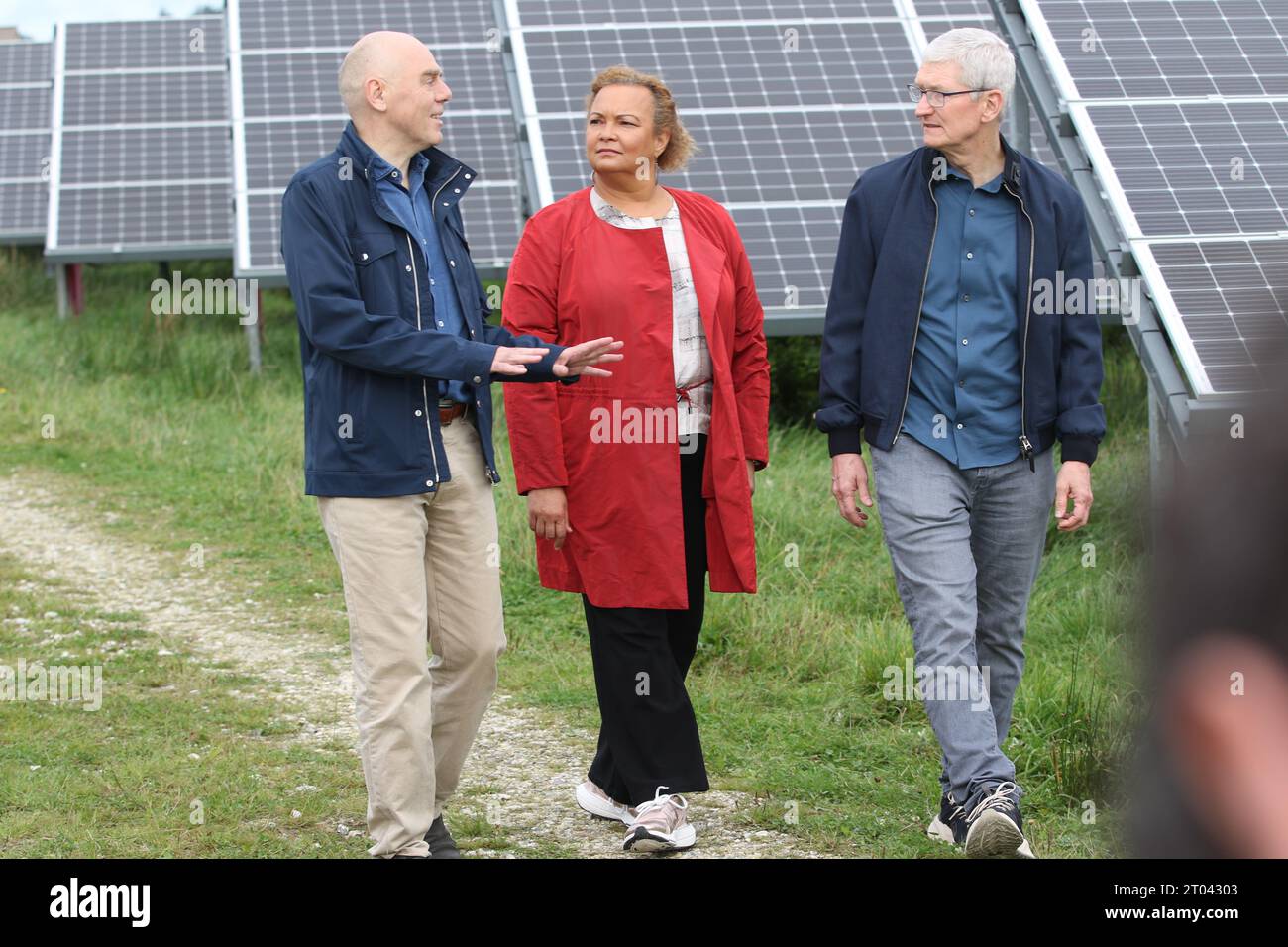 Hanstholm, Denmark. 27th Sep, 2023. Apple CEO Tim Cook (r) walks through a solar farm in Hanstholm, Denmark, with Apple sustainability chief Lisa Jackson and Erik Andersen, CEO of Danish company European Energy A/S. The solar panels are part of the renewable energy sources that power Apple's European data center in Viborg. Credit: Christoph Dernbach/dpa/Alamy Live News Stock Photo