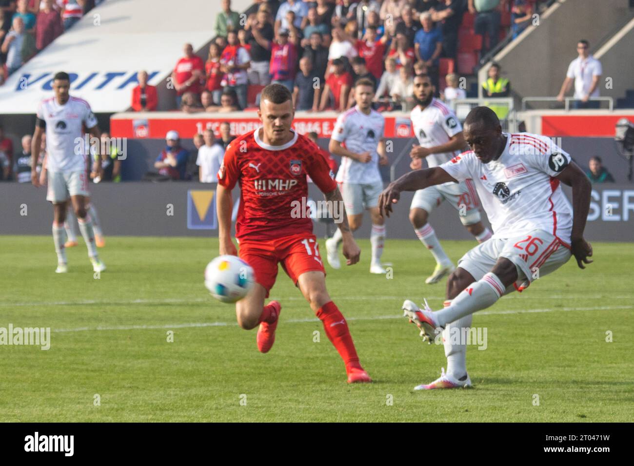 Jerome ROUSSILLION Union Berlin r. taking a shot, Florian PICK 1. FC Heidenheim can only look on Stock Photo