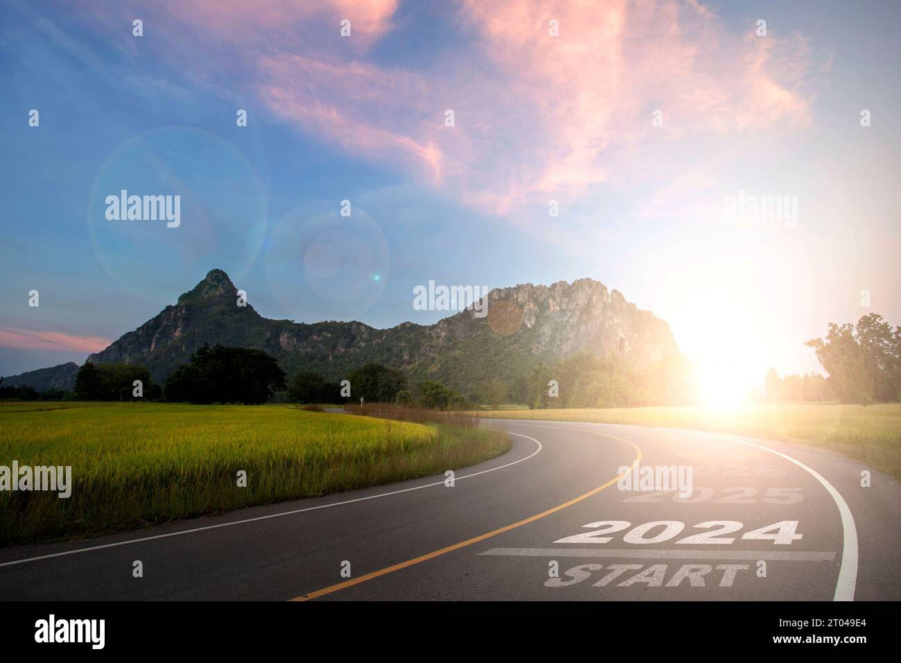 2024 New Year 2024 or the beginning of the concept, the word 2024 is written on the road in the middle of a paved road with sunset mountains in the ba Stock Photo
