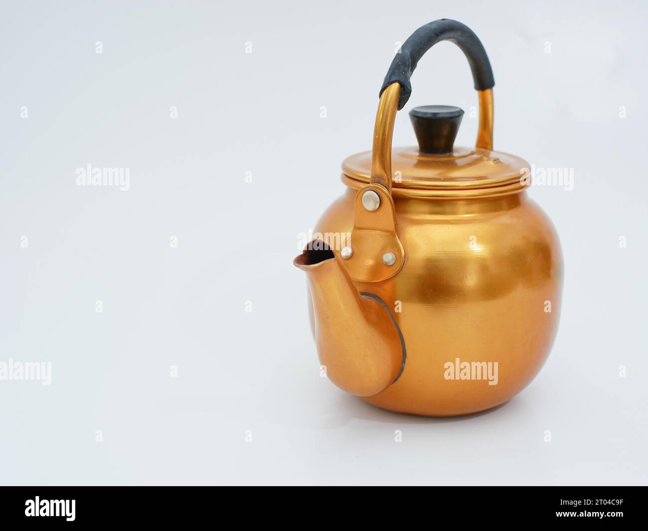 vintage gold toned aluminum tea kettle isolated on white background