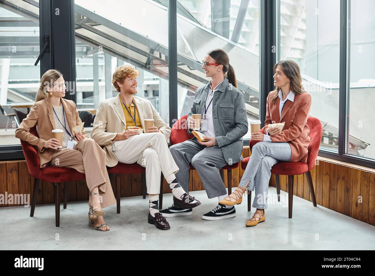 young teammates in business casual attire chatting and having lunch together, coworking concept Stock Photo