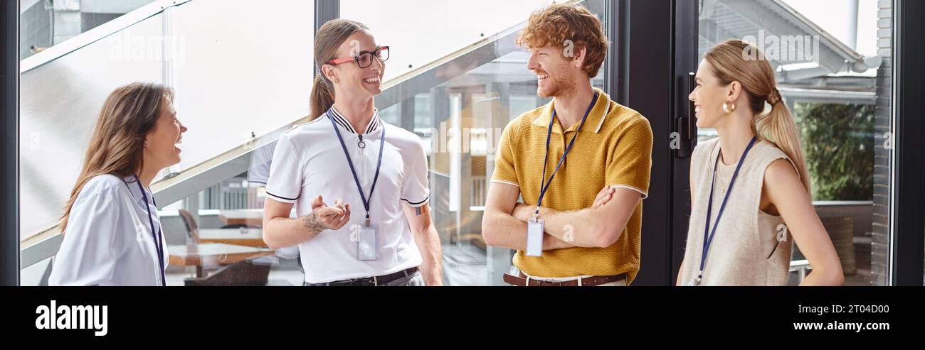cheerful employees in smart casual clothing smiling and discussing work, coworking concept, banner Stock Photo
