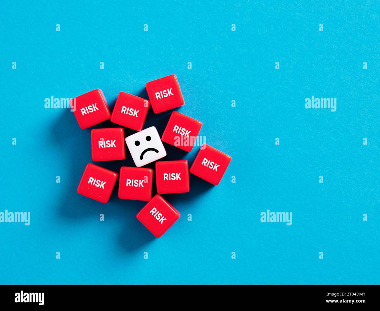 Extreme risk taking, stress and frustration. Too many risk factors. Risky business environment. Unhappy face surrounded with cubes with the word risk. Stock Photo