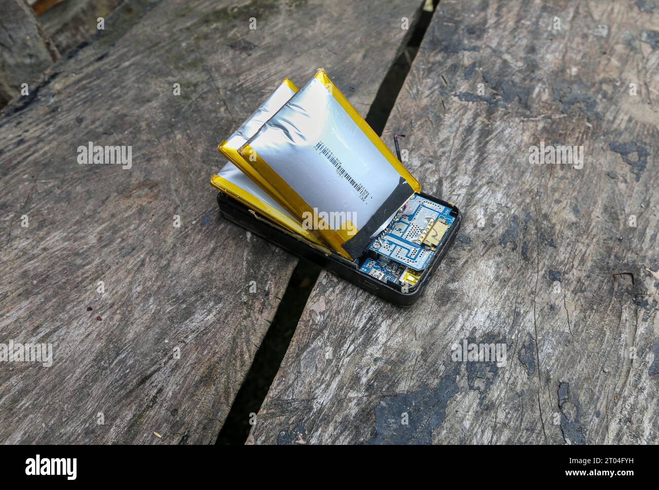 Dangerous swollen batteries ready to explode inside an external power bank, E-waste problem, electronics end of life, environmental impact Stock Photo