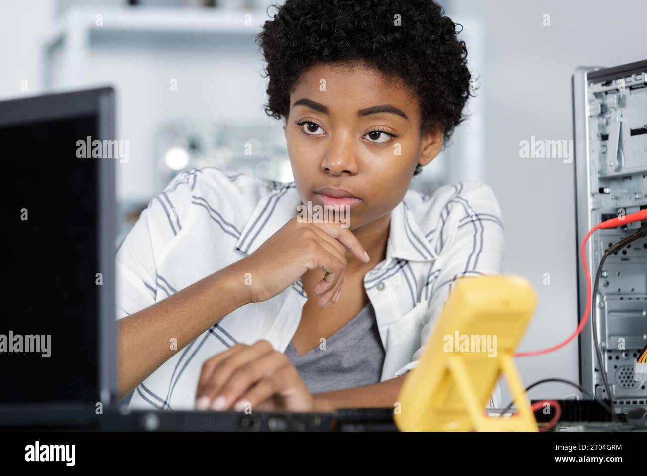 young computer technician typing on laptop Stock Photo