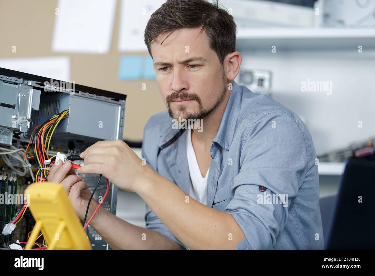 technician using voltage meter for voltage measurement in computer