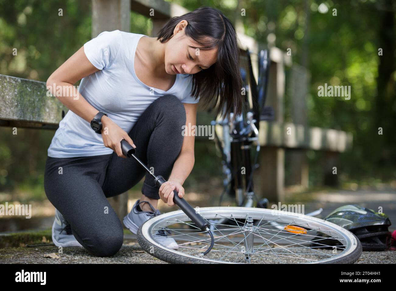 young woman pumping up a bike tire Stock Photo Alamy