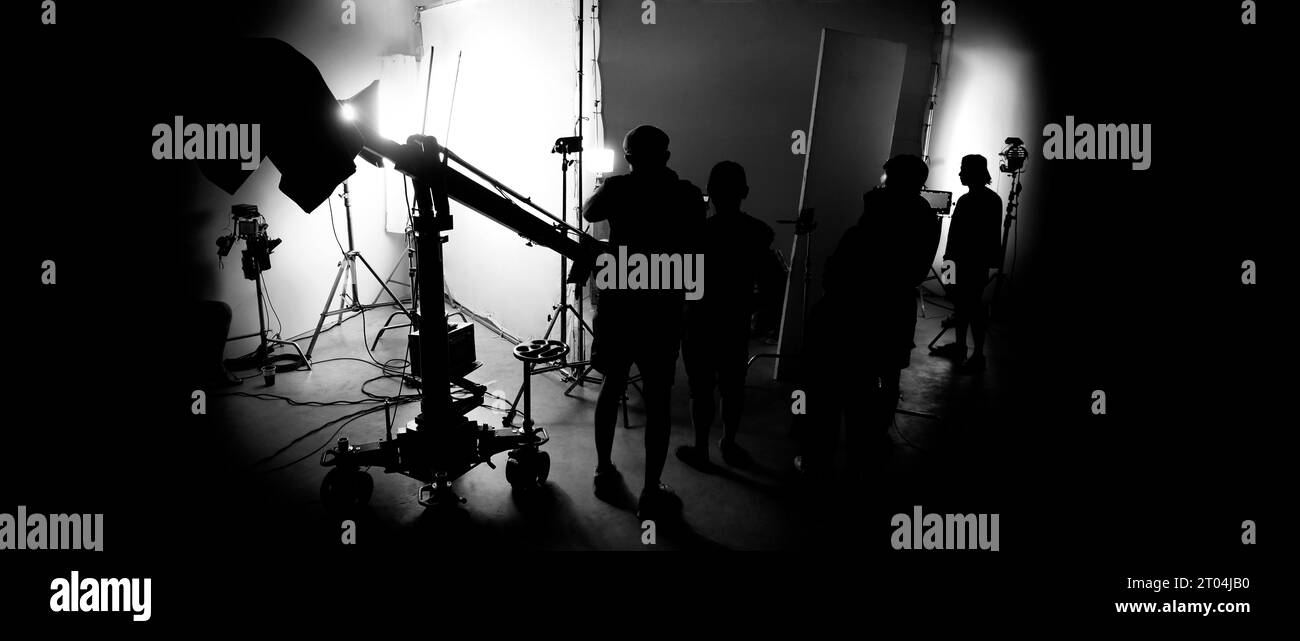 Silhouette images of making of or behind the scenes of video production which produced in the film studio that include all pro light and camera equipm Stock Photo