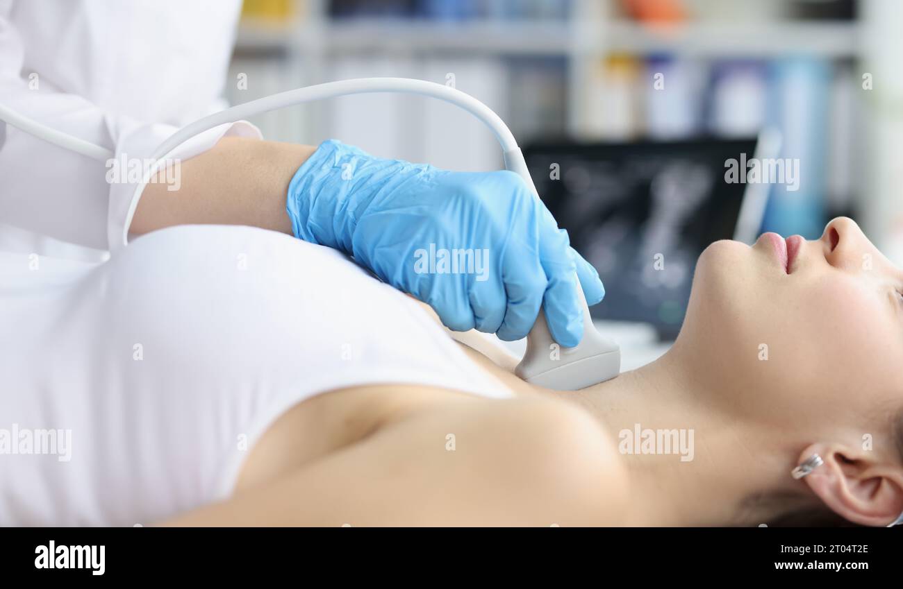 Woman receives ultrasound of thyroid gland from doctor stock photo alamy