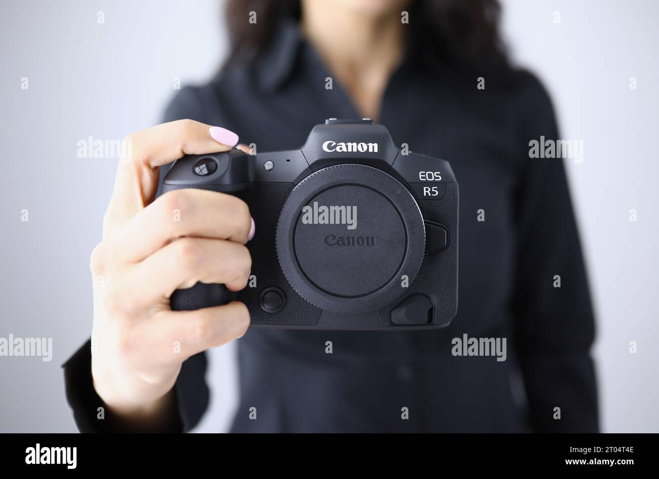 Tbilisi, Georgia - July 26, 2022: Person holding modern Canon EOS R5 camera closeup in hand Stock Photo