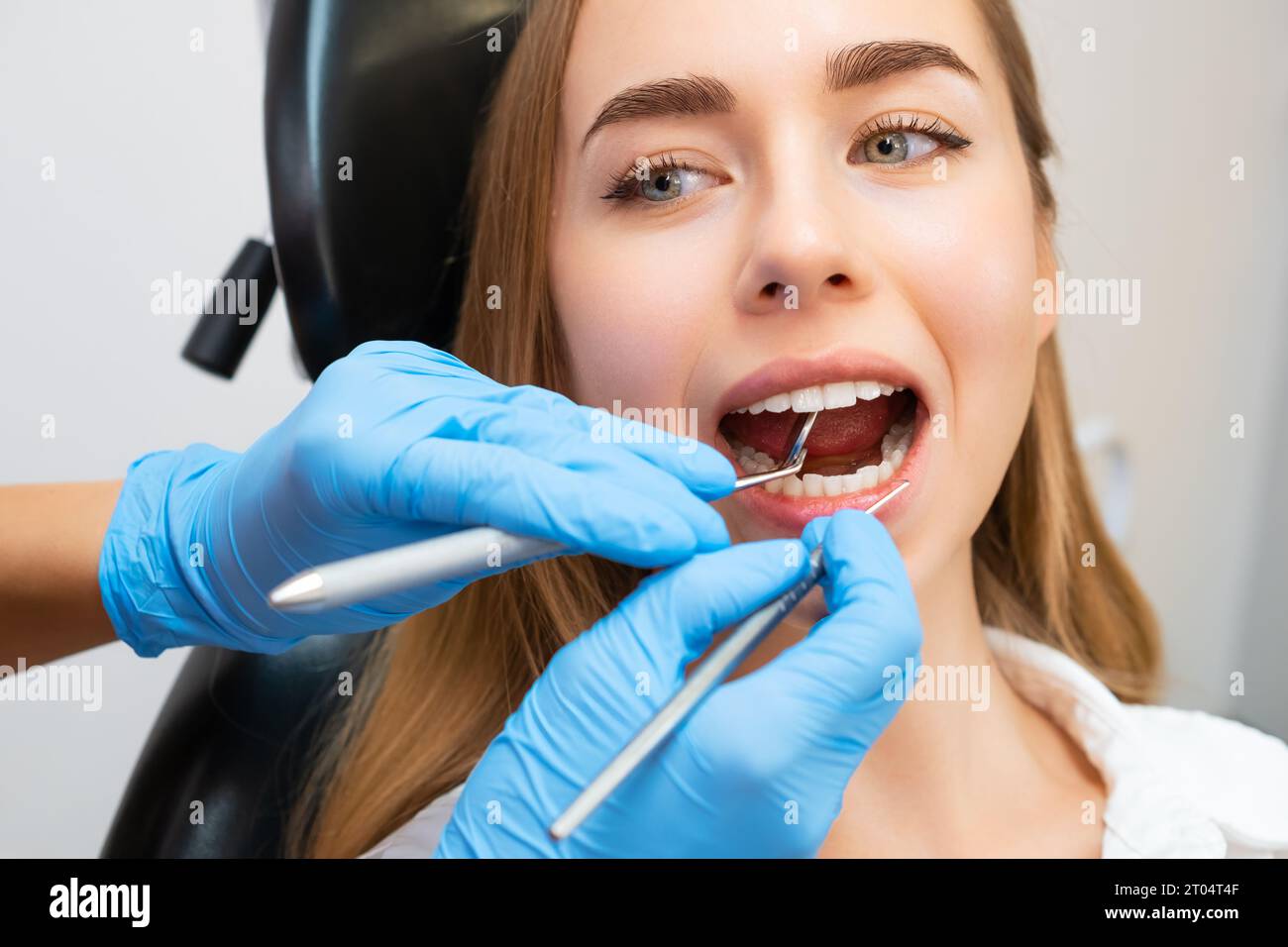 Woman patient sitting on chair during teeth procedures in dental clinic
