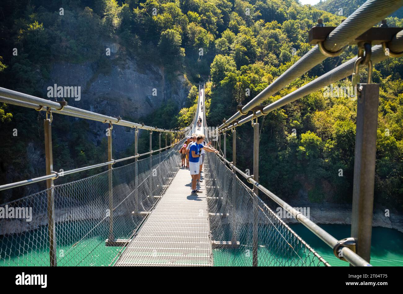 People cross the Passerelle du Drac (Drac Footbridge) over Lake Monteynard Avignonet in an area of outstanding natural beauty in the French Alps, Mayr Stock Photo