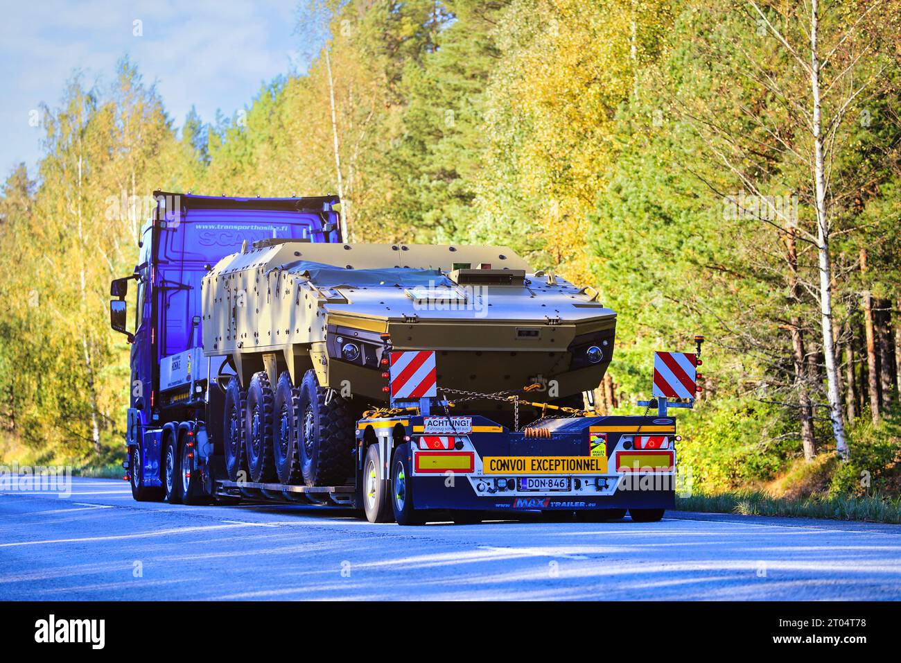 Scania truck transports Red Cross military rescue vehicle on lowboy trailer along highway as exceptional load. Raasepori, Finland. Sept 22, 2023. Stock Photo