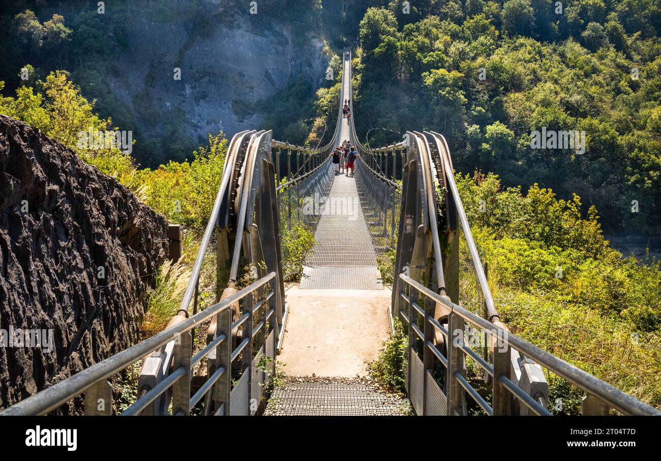 People cross the Passerelle du Drac (Drac Footbridge) over Lake Monteynard Avignonet in an area of outstanding natural beauty in the French Alps, Mayr Stock Photo