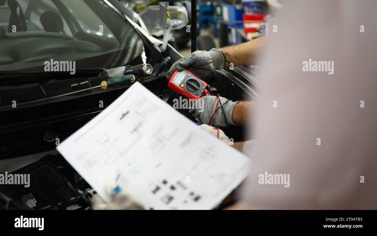 Mechanical service using multimeter to check voltage level in car