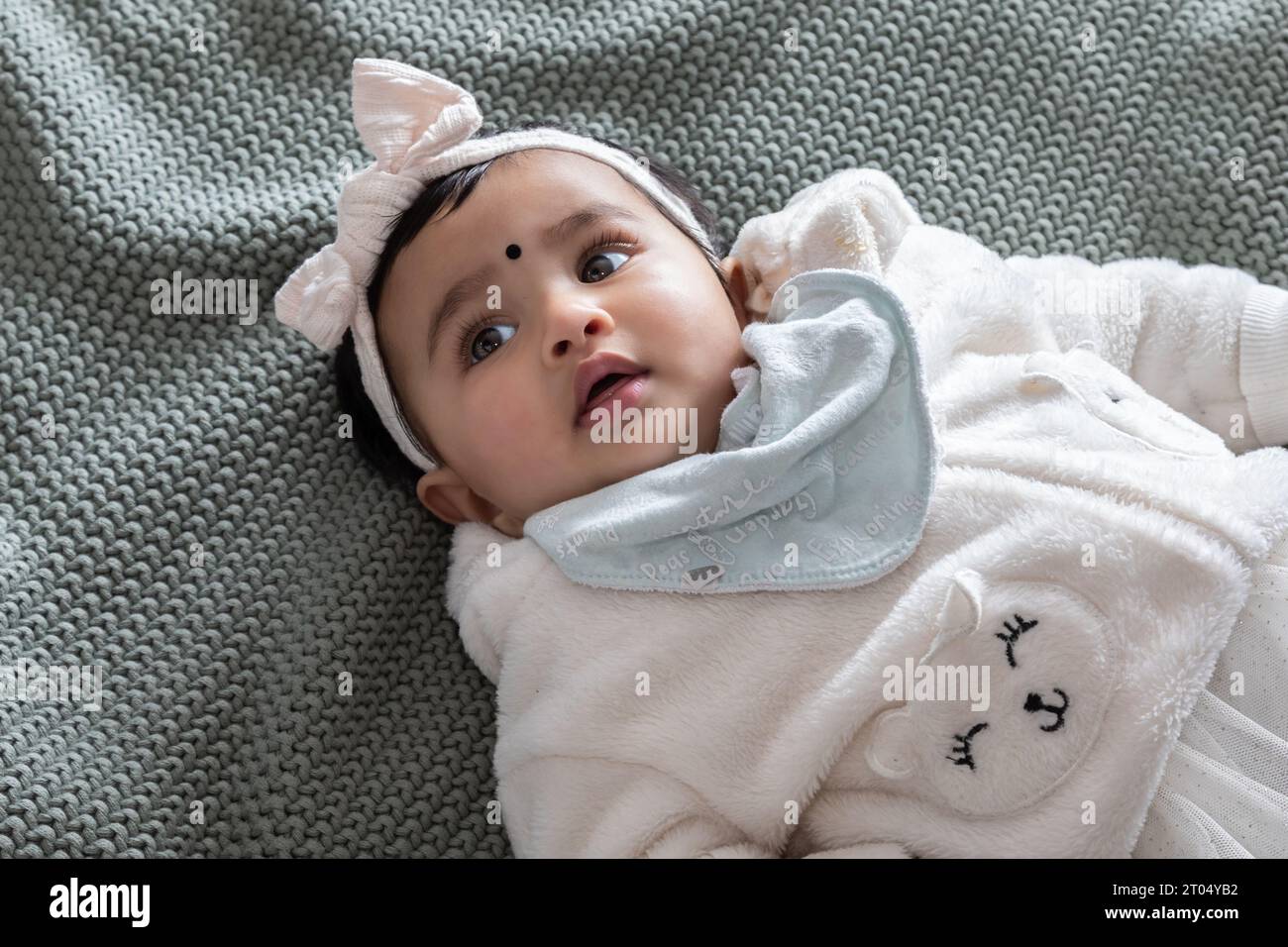 A close-up image of an Indian baby girl dressed in pink radiates pure innocence and joy with her bright eyes Stock Photo