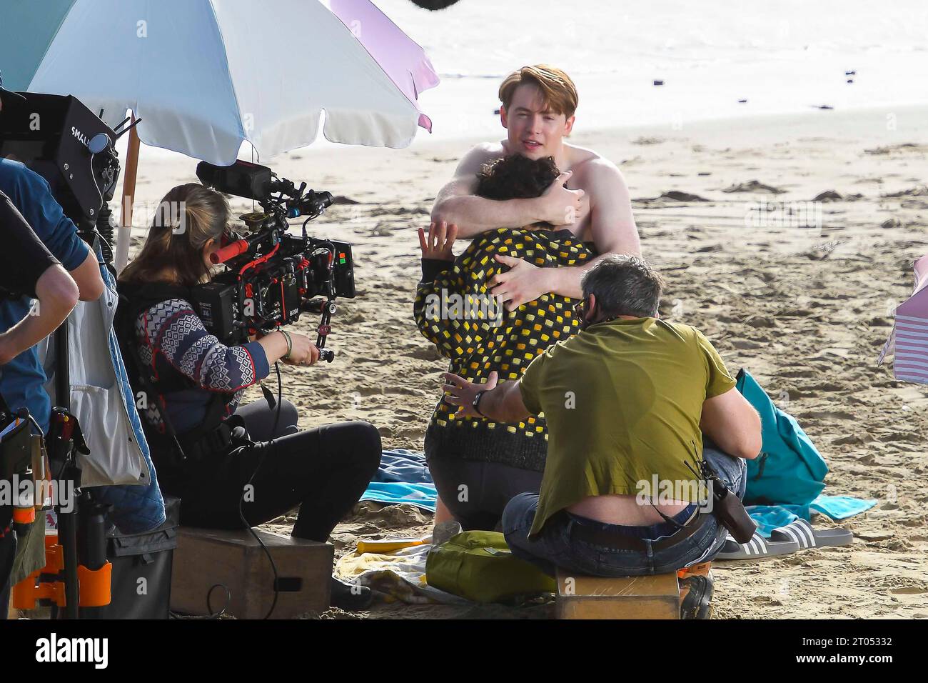 Lyme Regis, Dorset, UK.  4th October 2023.  Filming on the beach at Lyme Regis in Dorset for 3rd series of the Netflix LGBTQ+ drama Heartstopper, about teen friendship and young romance based on the graphic novel by Alice Oseman, starring Kit Connor as Nick Nelson and Joe Locke as Charlie Spring.  Actors Kit Connor and Joe Lock filming an intimate scene on the beach.  Picture Credit: Graham Hunt/Alamy Live News Stock Photo