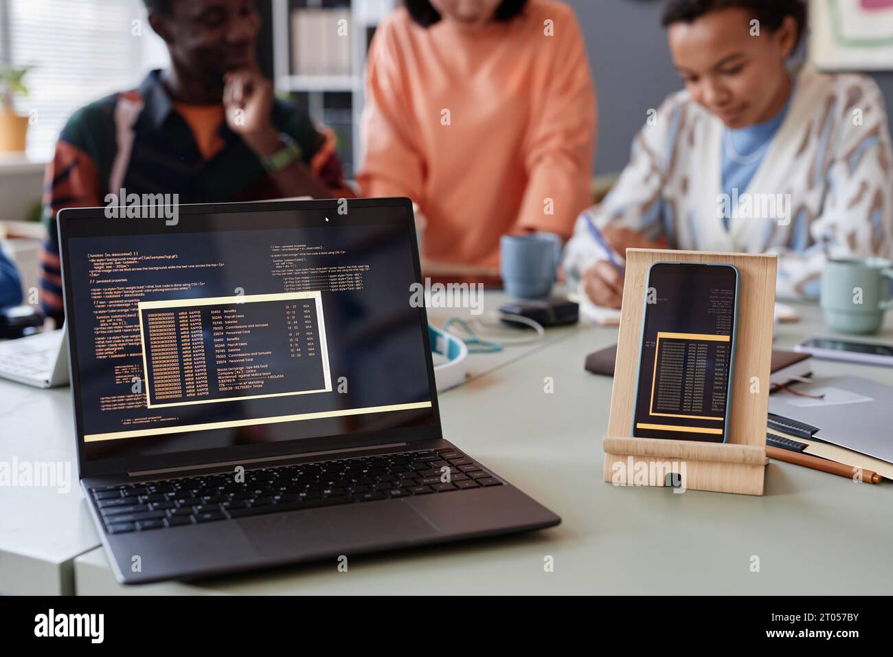 Close up of laptop and smartphone with programming code lines on screen, copy space Stock Photo