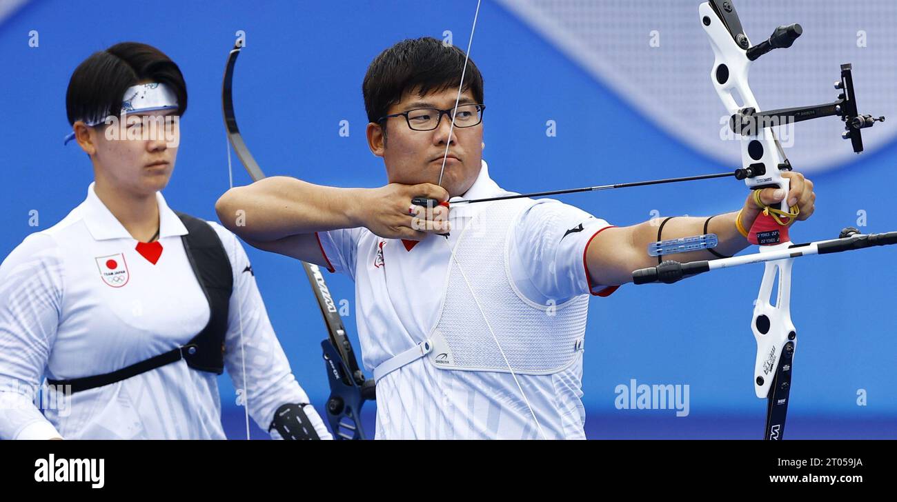 Japan's Takaharu Furukawa aims at a target as Satuki Noda looks on during  the recurve mixed team archery semifinal at the Asian Games in Hangzhou,  China, on Oct. 4, 2023. (Kyodo)==Kyodo Photo