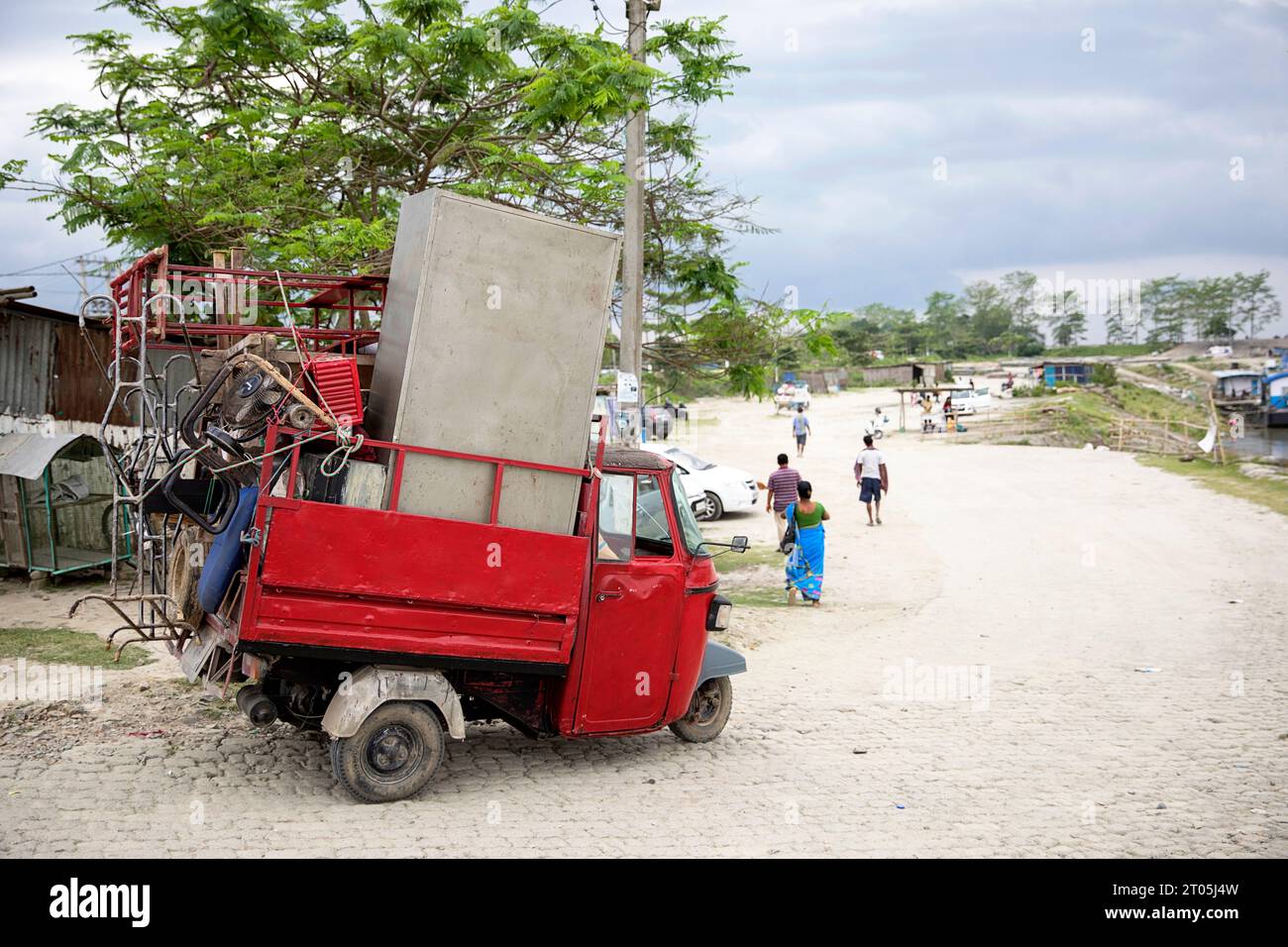 Overloaded Small car transporting goods to a port on Brahmaputra river for a ferry crossing to Majuli island, Assam, India Stock Photo