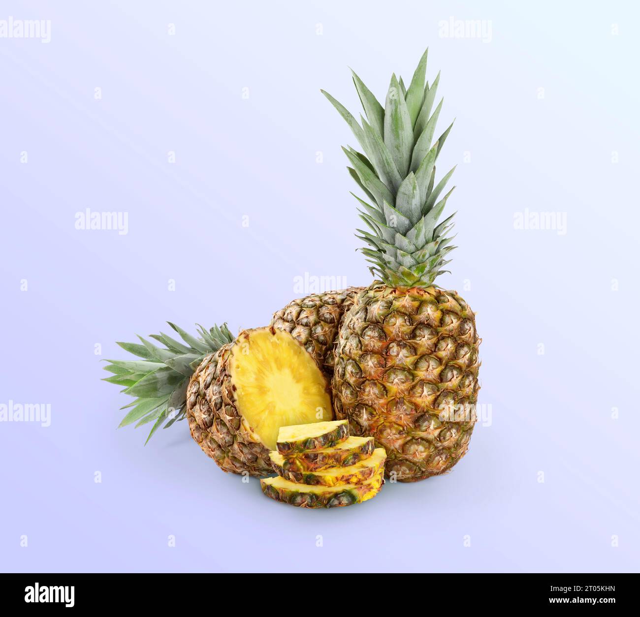 Cut and whole pineapples on light blue background Stock Photo
