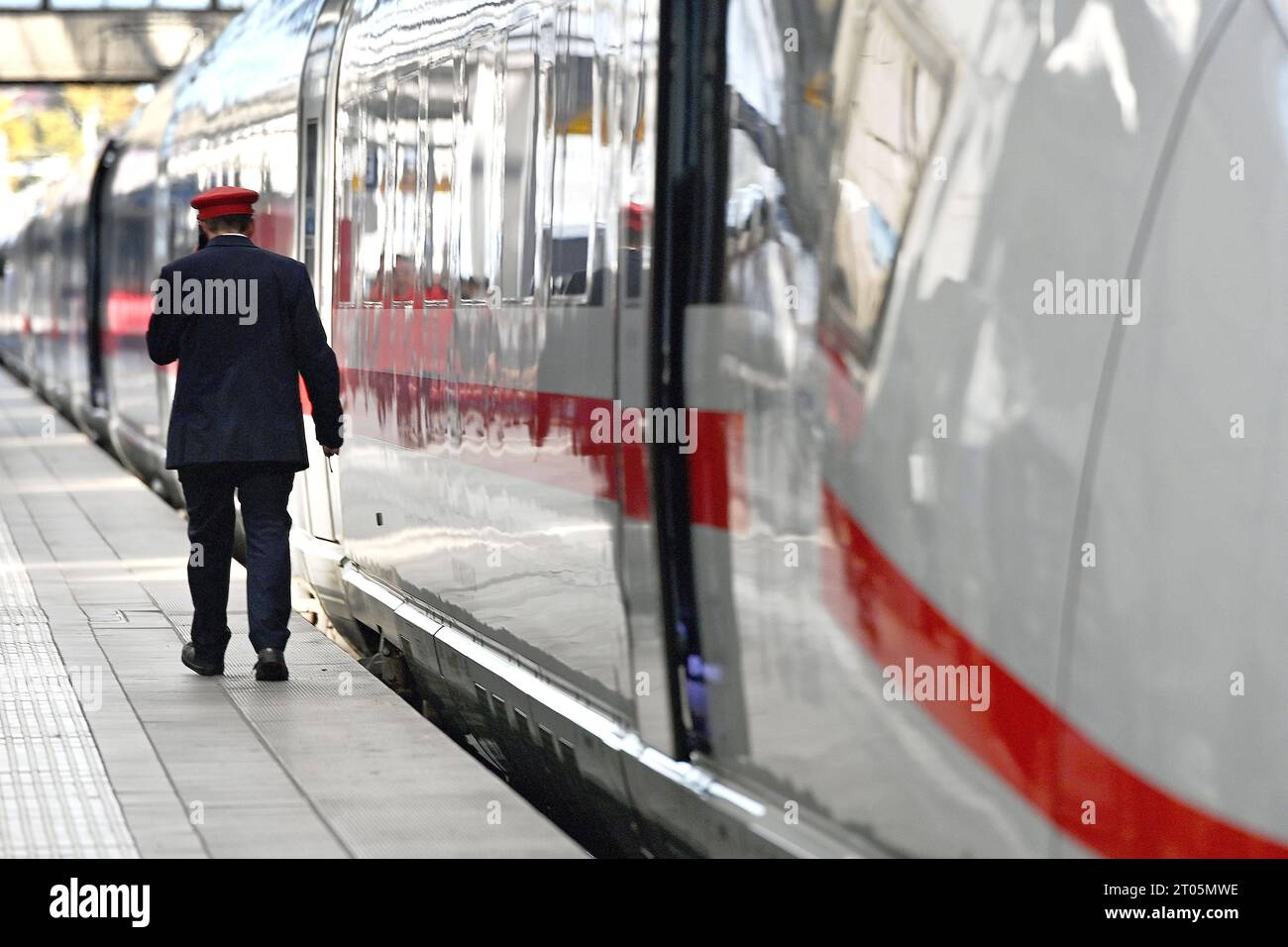 Zugfuehrer, Schaffner, Zugbegleiter geht an einem ICE entlang.Intercity