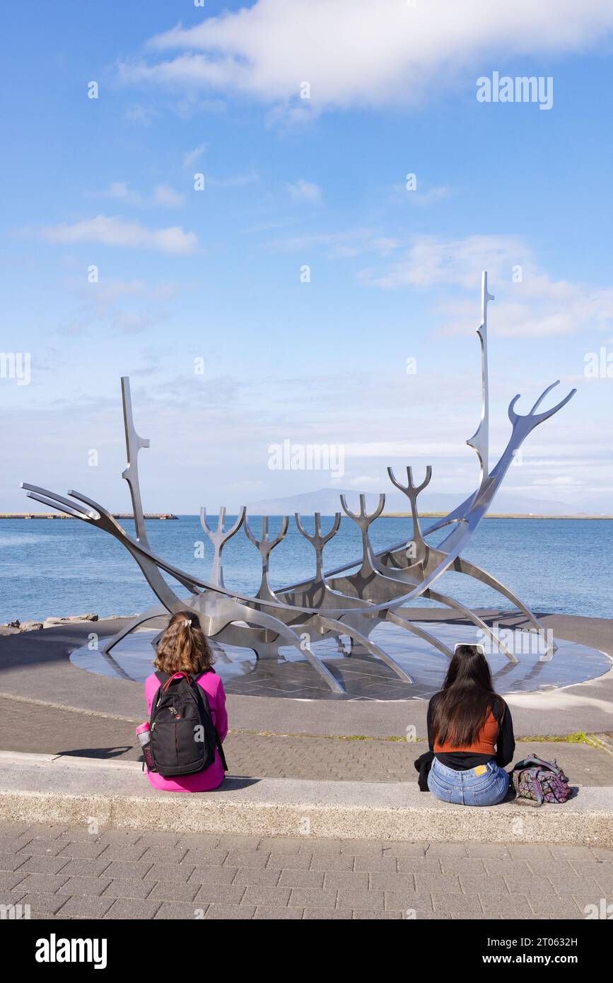 Two tourists at the Sun Voyager sculpture, by Jón Gunnar Arnason, created in 1987 on the shore in Reykjavik. Reykjavik, Iceland. Summer, Travel. Stock Photo