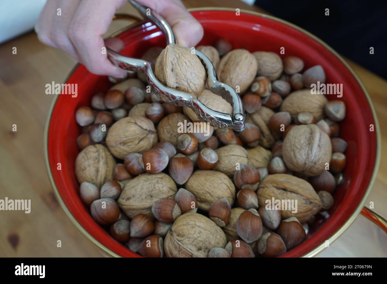 Cracking the walnuts and hazelnuts in the bowl. Cracking walnuts with a