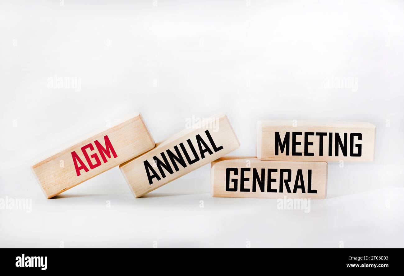 AGM is the symbol of the annual general meeting. Concept word AGM on wooden cubes. White background.Copy space. Stock Photo