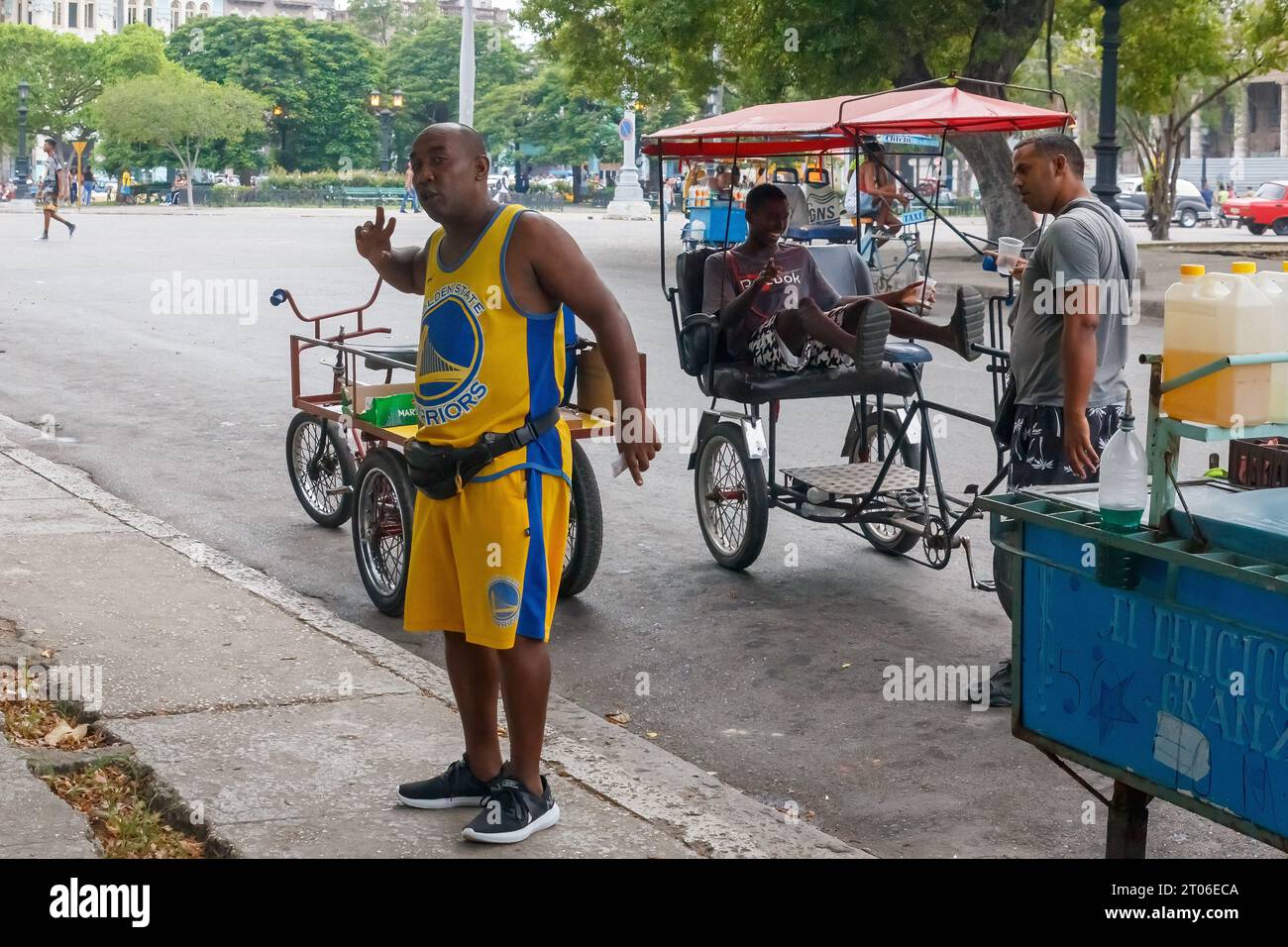 A Cuban man wearing sports clothes works selling flavored ice in the downtown district. Candid portrait of real people in street settings. Stock Photo