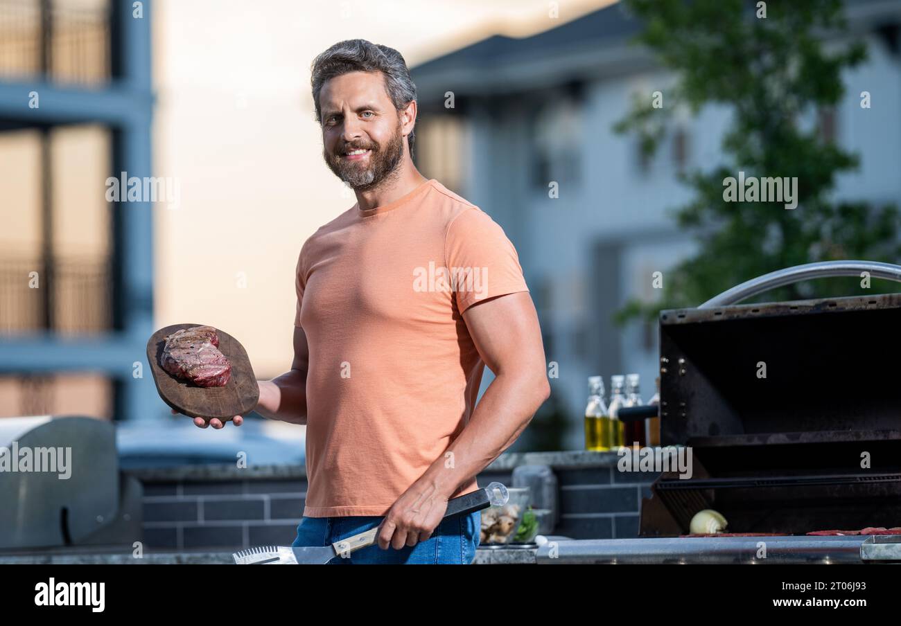 Man enjoying barbecuing. Grill guru smoky prowess. man grilling his favorite meats. cook showcasing his barbecue techniques at cookout event. Stock Photo