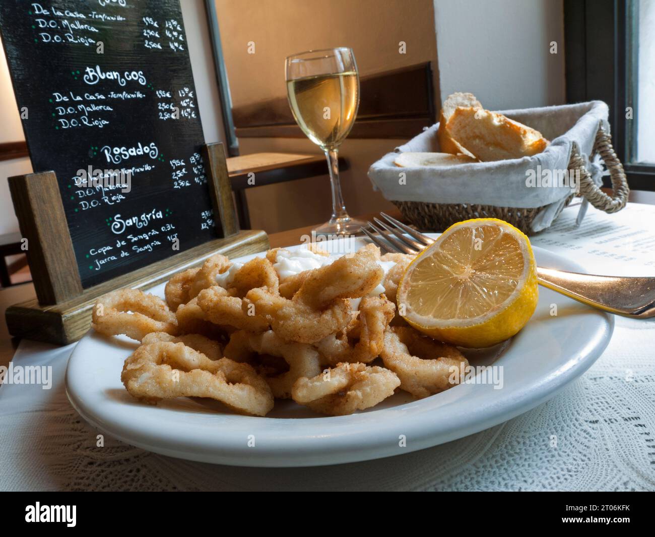 TAPAS BAR PALMA SPAIN Fried Calamari tapas and glass of white wine in